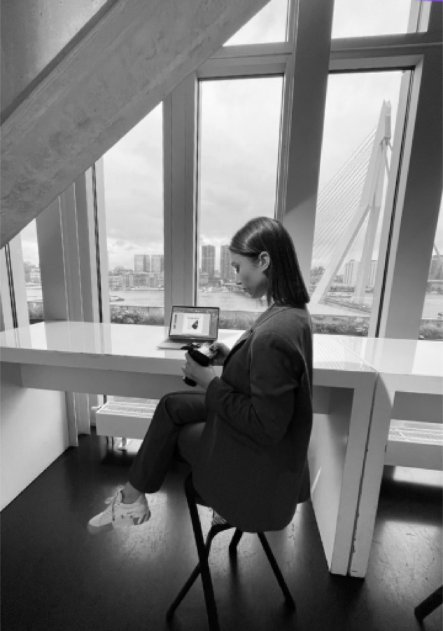 Oumayma, founder van Pittr, achter haar laptop met uitzicht op de Erasmusbrug